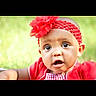 baby, child, closeup, curious, cute, expression, eyes, face, fashion_accessory, flower, green_background, headband, infant, natural_light, outdoor, portrait, red_clothing, skin, summer, young_child