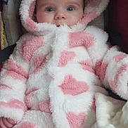 Léna participe au concours pour gagner de l'argent avec cette photo : baby, child, infant, hood, pink, white, fluffy, coat, warm, cute, face, eyes, hands, blanket, car_seat, soft, clothing, portrait, indoor, adorable