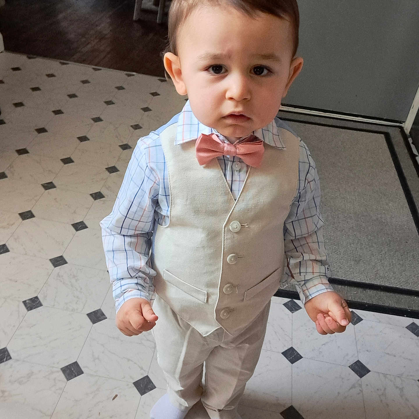 Liam joined the competition — help win amazing prizes! bow_tie, boy, carpet, child, clothing, door, expression, floor_tiles, formal_wear, hair, home, indoor, light, patterned_floor, plaid_shirt, serious, socks, standing, toddler, vest