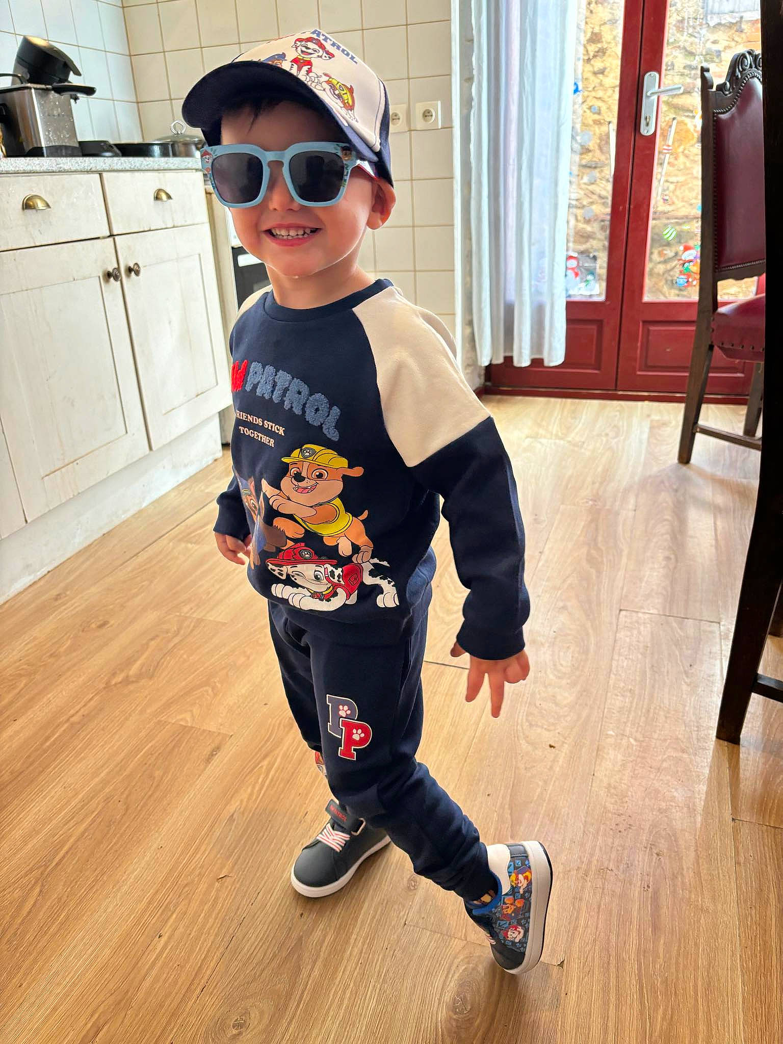 Sauveur participe au concours pour gagner de l'argent avec cette photo : baby_toddler_clothing, baseball_cap, cap, cool, eyewear, floor, flooring, goggles, happy, hardwood, joy, person, shoe, sleeve, smile, sportswear, sunglasses, t_shirt, toddler, vision_care