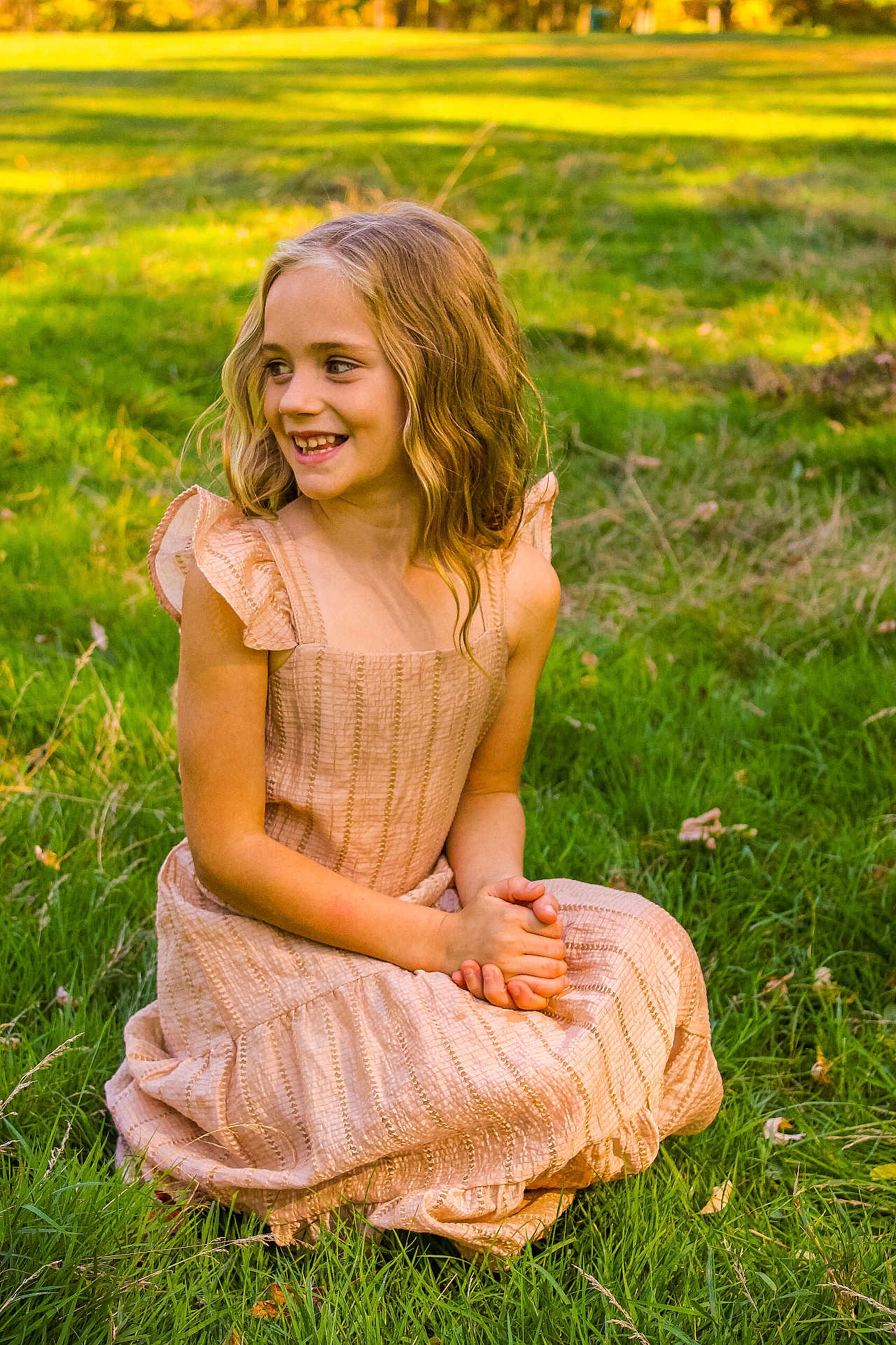 Ellianna is registered to the contest to win money with this photo: child, girl, smiling, outdoor, grass, dress, sunlight, nature, greenery, happy, sitting, wavy_hair, pretty, young, portrait, daylight, casual, cute, childhood, summer