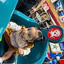 Zylah is registered to the contest to win money with this photo: bib, car_ride, carpet, chairs, child, curious, floor, indoor, kiddie_ride, man, person, pigtails, police_ride, red_seat, restaurant, snack, table, teal_seat, toddler, toy