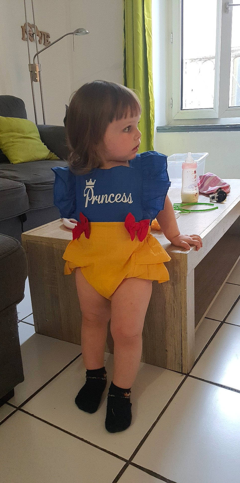 Meï participe au concours pour gagner de l'argent avec cette photo : floor, flooring, fun, hair, human_body, human_leg, knee, leg, person, shoe, shorts, shoulder, sneakers, sportswear, t_shirt, table, thigh, toddler, trunk, waist