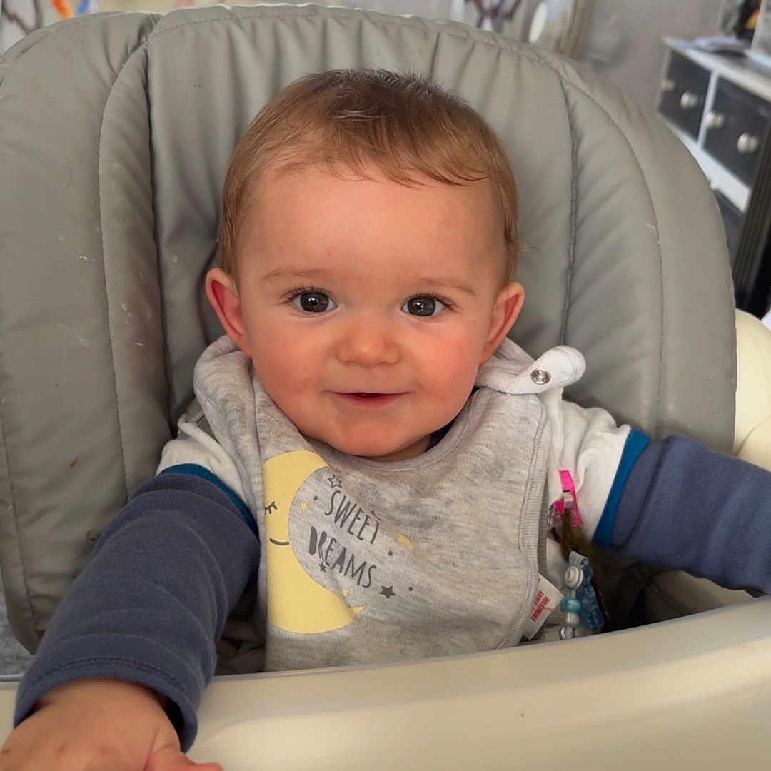 Kaiden-Bryan joined the competition — help win amazing prizes! baby, bib, child, clothing, curtains, cute, expression, face, furniture, hand, happy, high_chair, home, indoor, infant, person, reaching, smiling, window, young