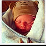 Carson is registered to the contest to win money with this photo: newborn, baby, sleeping, hat, bear_hat, blanket, cozy, face, infant, cute, soft_texture, wrapped, hand, peaceful, portrait, child, indoors, resting, warm, polaroid_frame