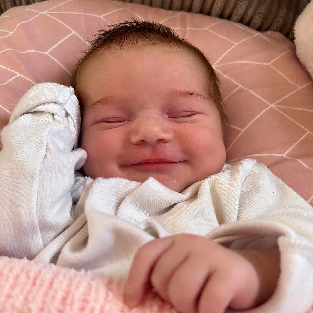 Arabella Rose joined the competition — help win amazing prizes! baby, blanket, child, comfort, cozy, cushion, cute, face, hand, indoors, infant, newborn, peaceful, pink, portrait, resting, sleepy, smiling, soft_texture, white_clothing