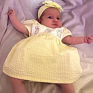 Arabella Rose is registered to the contest to win money with this photo: baby, infant, yellow_dress, headband, blanket, white_socks, lying_down, soft_texture, cute, child, newborn, portrait, indoors, clothing, baby_girl, adorable, resting, headwear, small_arms, soft_lighting