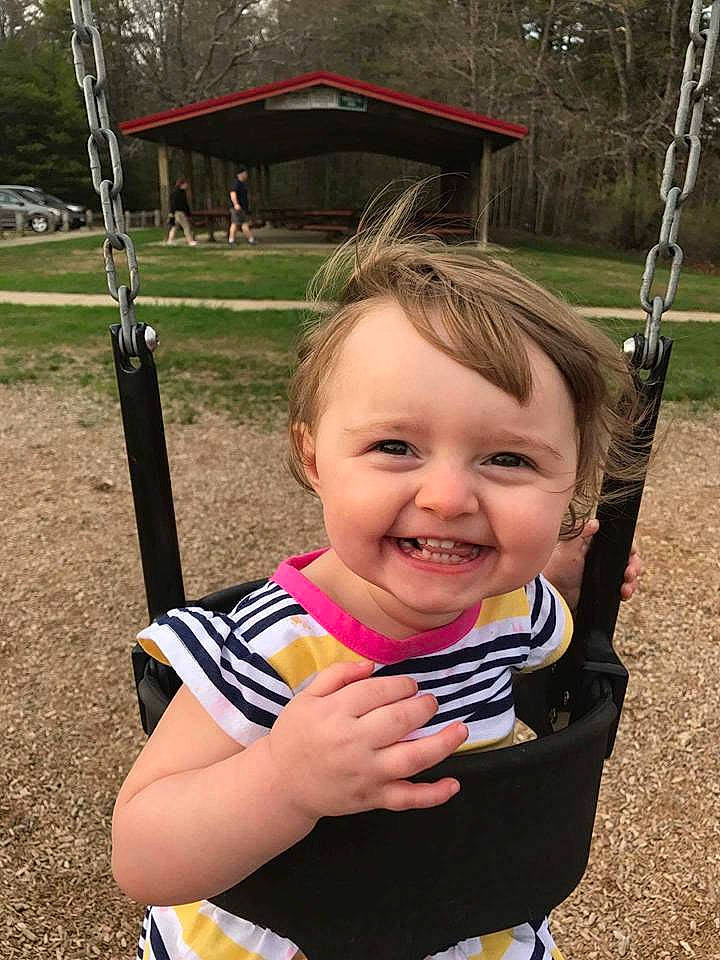 Emma is registered to the contest to win money with this photo: baby_products, child, day, emotion, facial_expression, fun, girl, grass, happiness, infant, joy, laughter, outdoor_play_equipment, person, play, product, recreation, sitting, smile, swing
