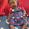 baby, infant, child, sleepy, blue_dress, red_shirt, headband, bed, blanket, patterned_clothing, stars, indoors, skin, legs, feet, hand, cute, resting, portrait, person