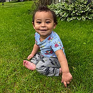 Lukas is registered to the contest to win money with this photo: toddler, child, grass, outdoor, smiling, blue_shirt, pants, barefoot, garden, plants, wooden_fence, greenery, happy, sitting, casual_clothing, daylight, portrait, playful, cute, nature