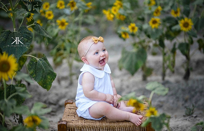 Ava is registered to the contest to win money with this photo: baby, child, flower, fun, happy, meadow, people_in_nature, person, photograph, photography, plant, portrait_photography, sitting, smile, spring, summer, sunflower, toddler, wildflower, yellow