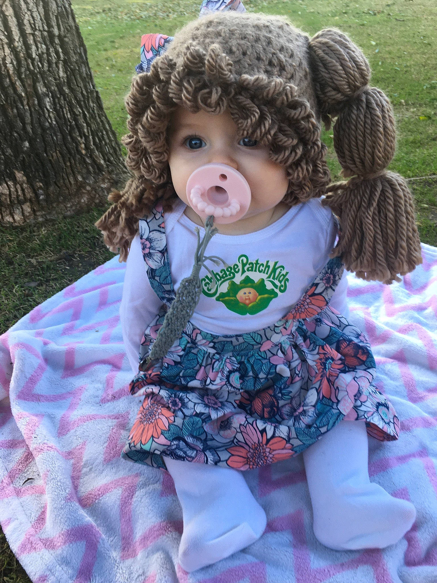 Raelyn joined the competition — help win amazing prizes! baby, baby_toddler_clothing, brown_hair, cheek, child, doll, dress, grass, pattern, person, pink, plant, recreation, toddler, toy
