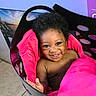 baby, smile, happy, child, laundry_basket, blanket, pink, indoor, cute, portrait, face, curly_hair, skin, expression, hand, playful, person, toddler, head, seated