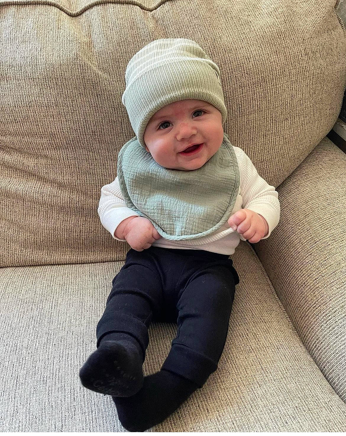 Graysen is registered to the contest to win money with this photo: baby, baby_toddler_clothing, cap, cheek, child, comfort, face, facial_expression, fashion_accessory, headwear, human_body, knit_cap, leg, linens, outerwear, pattern, person, sitting, skin, sleeve