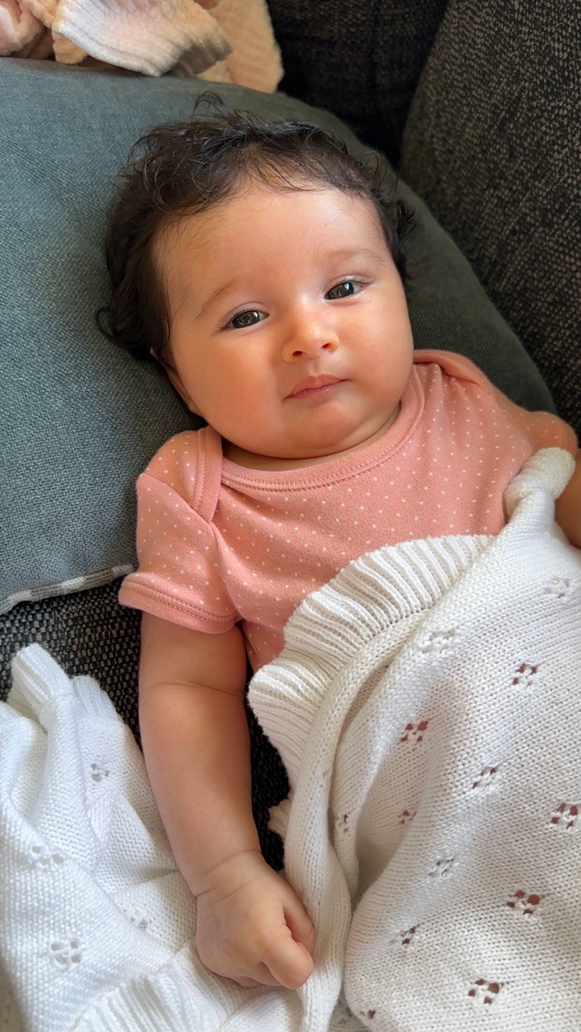 Amirah is registered to the contest to win money with this photo: arm, baby, baby_products, baby_toddler_clothing, cheek, child, comfort, eyelash, face, finger, hair, iris, linens, lip, nose, person, skin, sleeve, smile, thumb