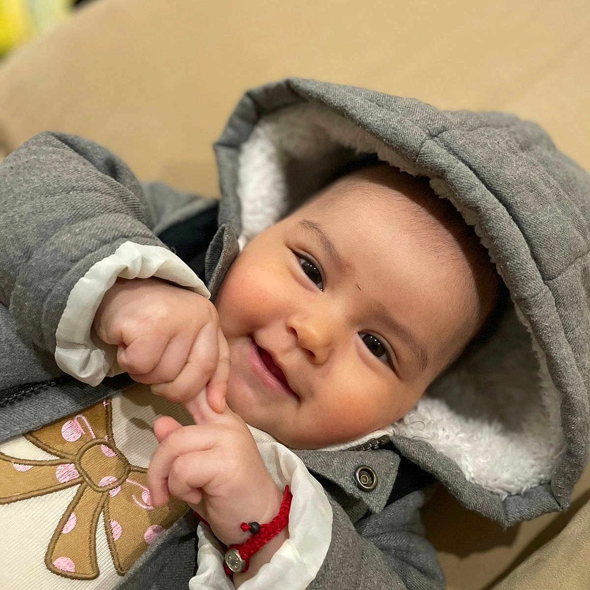 Amaya Nicol is registered to the contest to win money with this photo: baby, baby_girl, casual, child, closeup, comfortable, cute, cute_expression, face, gray_jacket, hands, happy, hood, indoor, infant, portrait, red_bracelet, smile, soft_texture, warm_clothing