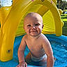Titan is registered to the contest to win money with this photo: baby, child, smiling, pool, water, inflatable, sun_canopy, outdoor, summer, play, fun, happy, diaper, sunlight, blue, yellow, skin, hand, nature, grass