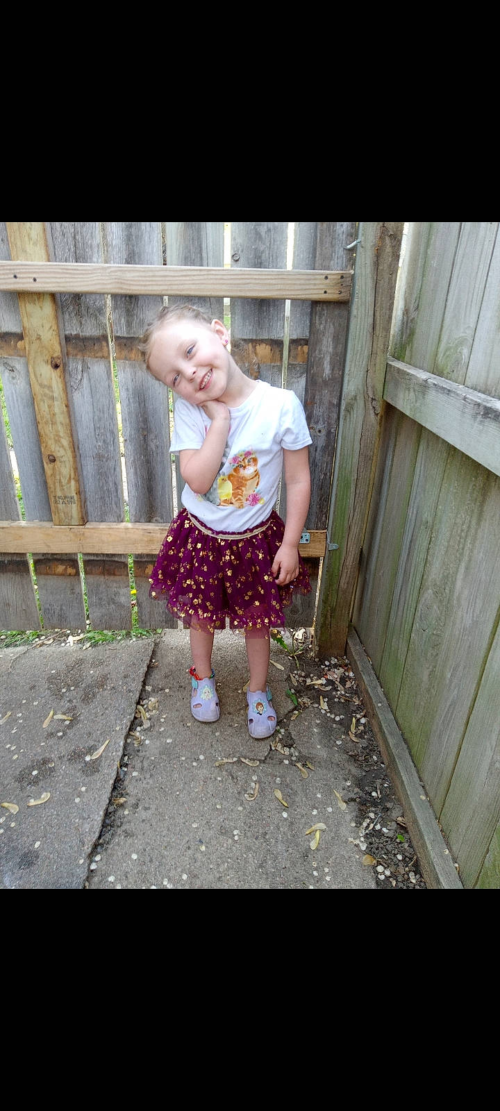 Jazmyn is registered to the contest to win money with this photo: baby, baby_toddler_clothing, child, clothing, fence, fun, grass, happy, human_body, human_leg, joy, leg, leisure, magenta, pattern, person, shorts, sitting, smile, t_shirt