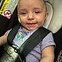 baby, child, car_seat, safety_harness, smile, face, infant, striped_shirt, embroidery, seatbelt, cute, happy, closeup, indoors, person, young_child, seat, car, child_safety, baby_clothing