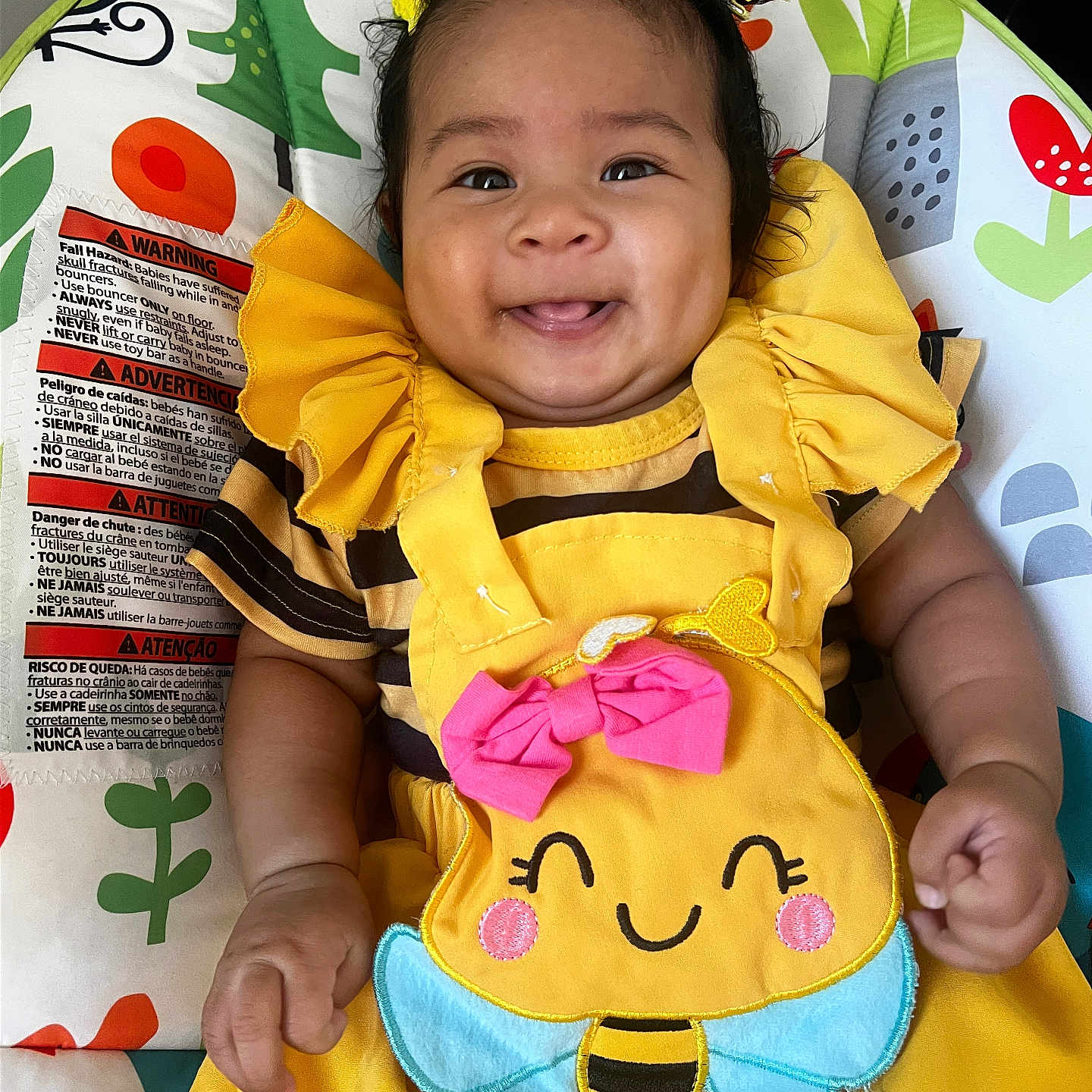 Amira joined the competition — help win amazing prizes! baby, child, smiling, yellow_clothing, cute, infant, baby_chair, colorful, happy, face, portrait, indoors, cute_outfit, playful, adorable, person, baby_accessory, hair_bow, seat, cheerful