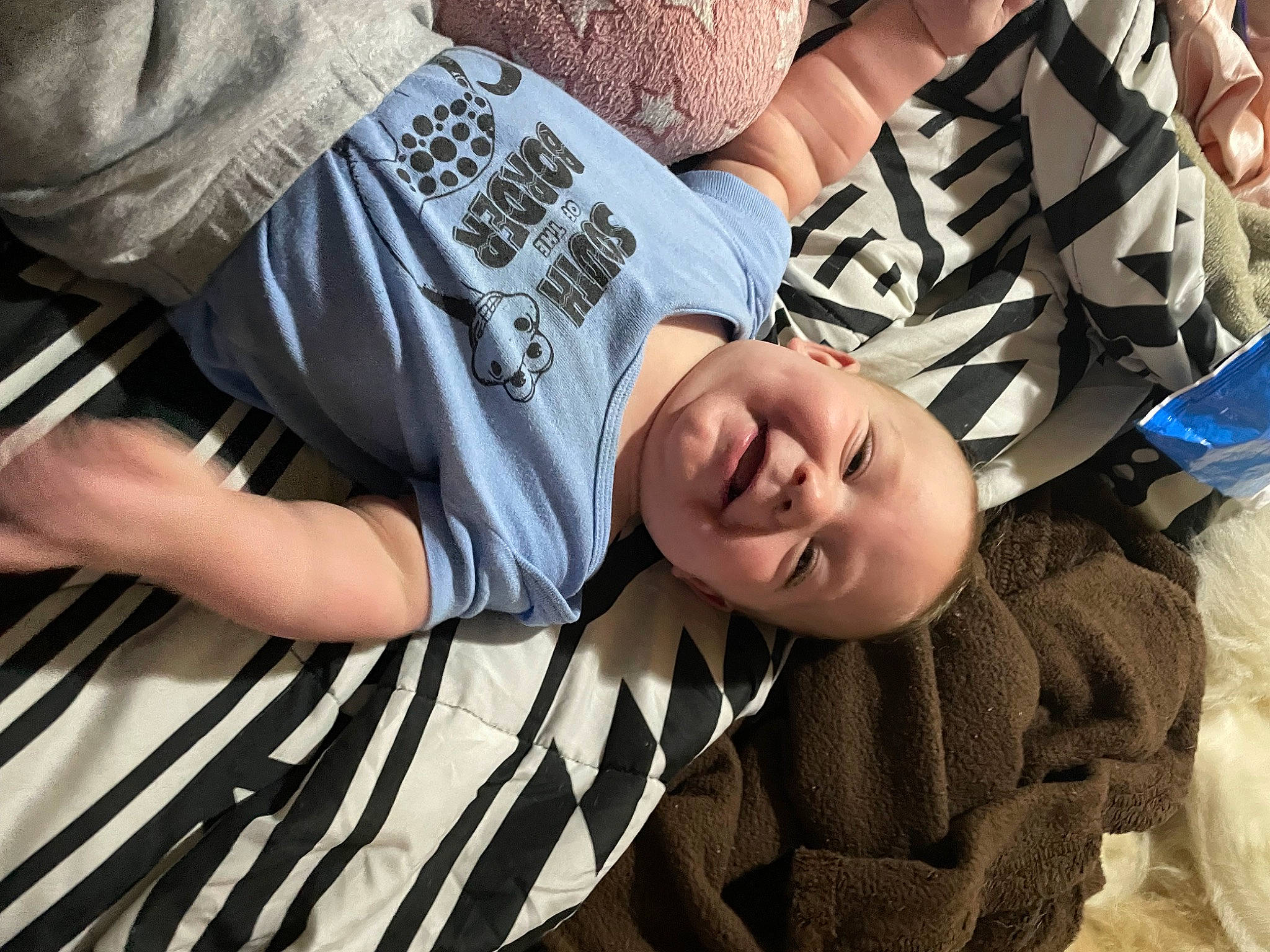 Canaan is registered to the contest to win money with this photo: child, comfort, elbow, event, eyewear, fun, gesture, glasses, grass, happy, human_leg, linens, pattern, person, sitting, sleeve, smile, t_shirt, textile, thigh