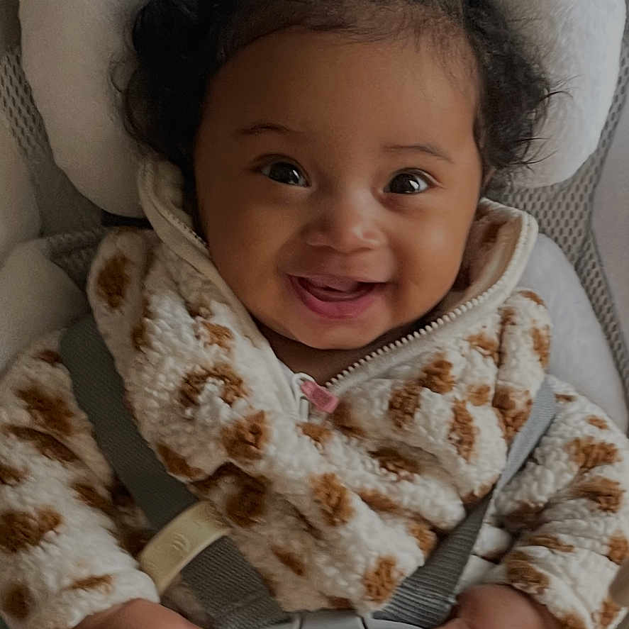 Athena is registered to the contest to win money with this photo: baby, bodypart, bonnet, clothing, couch, cushion, face, finger, furniture, hand, happy, hat, head, homedecor, knitwear, person, photography, portrait, smile, sweater