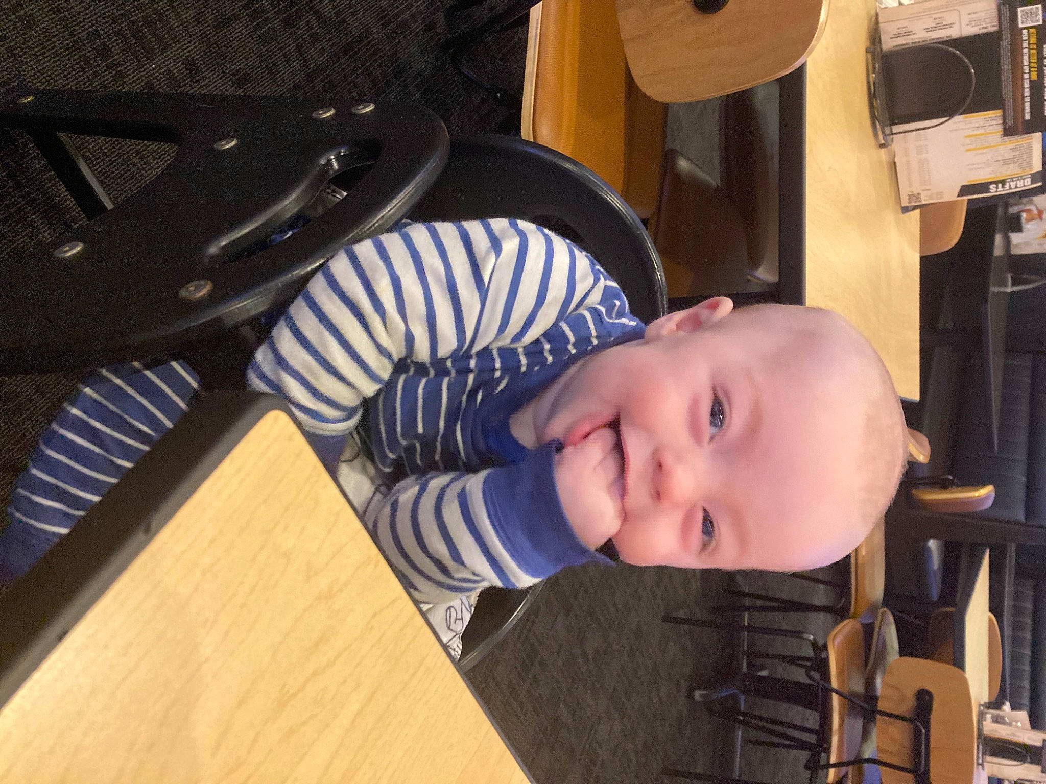 Kashton is registered to the contest to win money with this photo: audio_equipment, auto_part, automotive_wheel_system, baby, baby_toddler_clothing, child, flooring, fun, hairstyle, hardwood, hat, joy, loudspeaker, machine, musical_instrument, person, sitting, smile, t_shirt, table