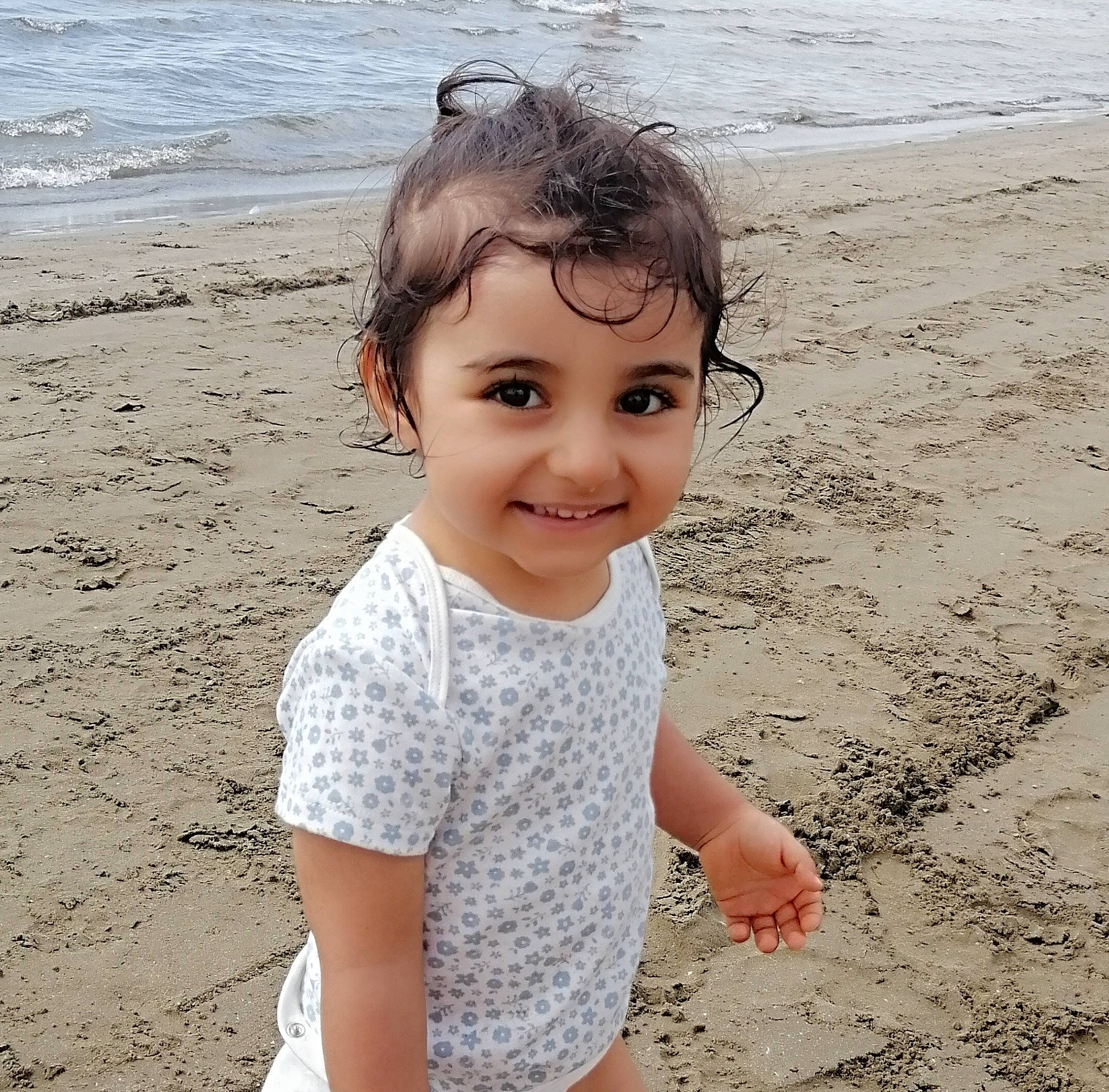 Angelina participe au concours pour gagner de l'argent avec cette photo : baby_toddler_clothing, beach, child, coast, fun, hair, happy, joy, people, people_in_nature, people_on_beach, person, play, sand, shore, skin, sleeve, smile, toddler, travel
