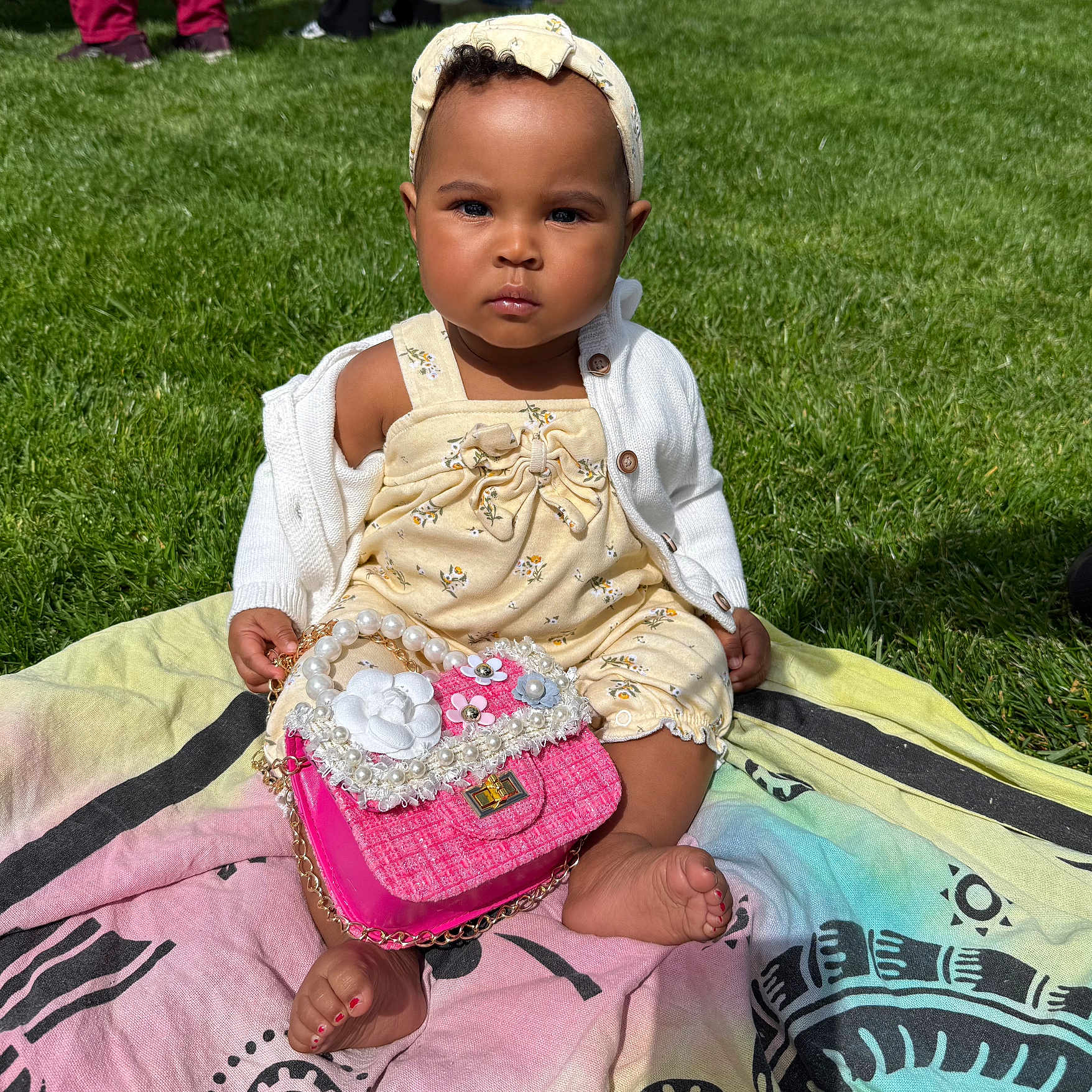 Kycee is registered to the contest to win money with this photo: accessories, baby, bag, clothing, dress, face, footwear, fun, grass, handbag, hat, head, lawn, person, photography, plant, portrait, purse, shoe, sitting
