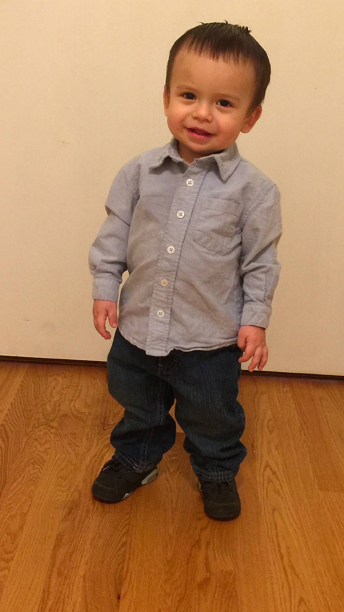 Emanuel is registered to the contest to win money with this photo: arm, child, floor, footwear, outerwear, person, shirt, shoe, sitting, sleeve, standing, t_shirt, toddler