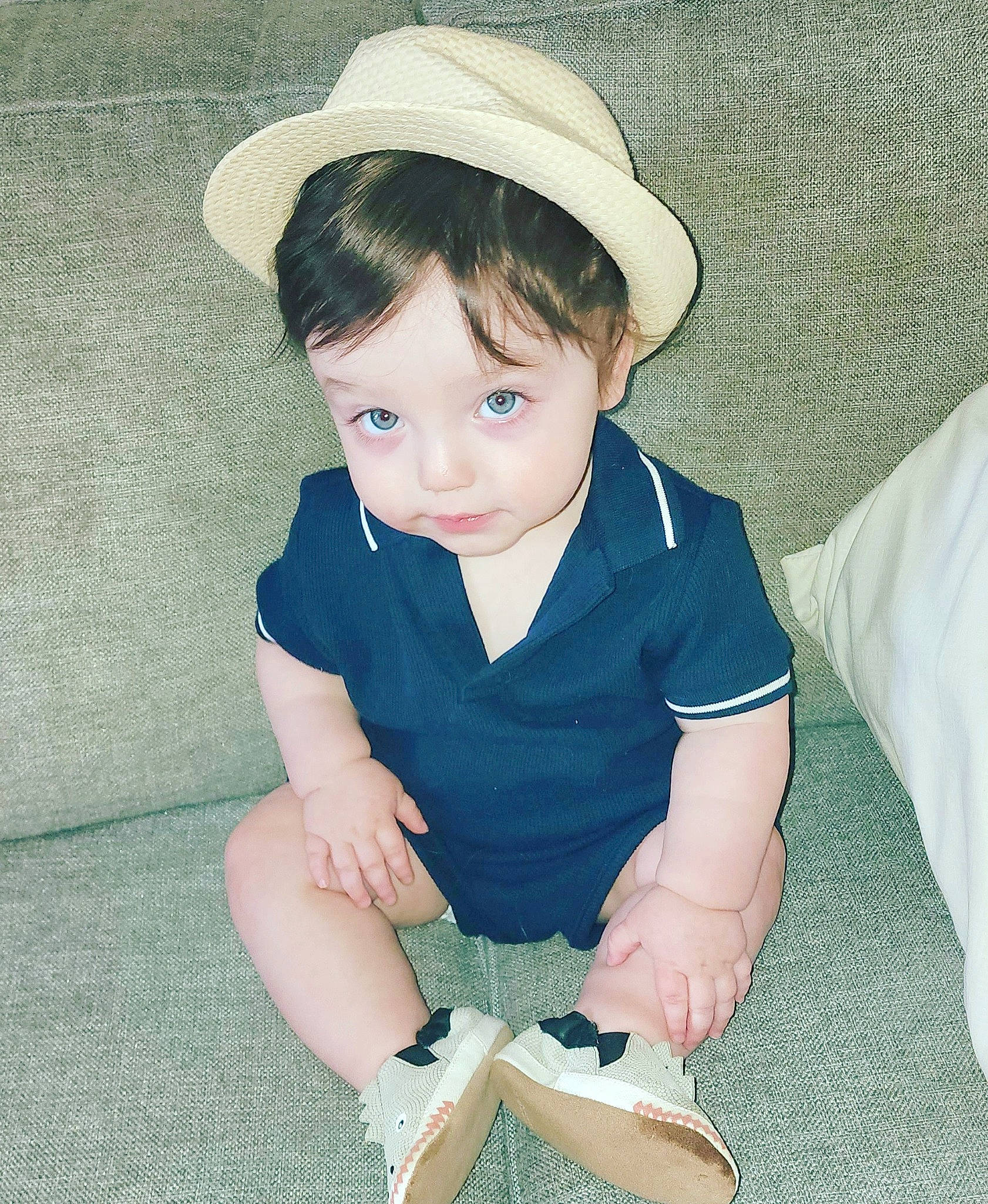 Luciano is registered to the contest to win money with this photo: arm, baby, baby_toddler_clothing, collar, cool, eye, face, flash_photography, grass, hair, hairstyle, hat, head, iris, knee, person, sleeve, sock, sun_hat, thigh