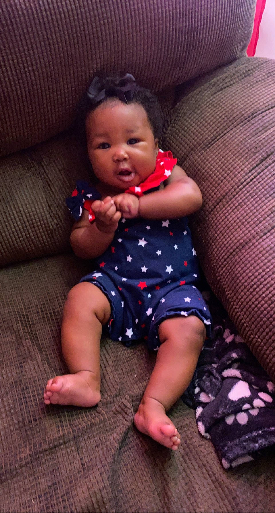 Jahzaria is registered to the contest to win money with this photo: baby, baby_toddler_clothing, cheek, child, comfort, couch, dress, face, finger, fun, head, mouth, pattern, person, purple, skin, smile, textile, thigh, toddler