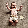 Lily joined the competition — help win amazing prizes! baby, infant, smiling, happy, lying_down, carpet, clothing, pink_top, white_shorts, milestone, wooden_sign, seven_months, arms_raised, chubby, cute, indoor, portrait, child, person, face
