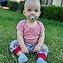 baby, child, grass, outdoor, pacifier, sitting, pajamas, shirt, blue_eyes, cute, infant, nature, greenery, daylight, young_child, person, sock, casual_clothing, background_blur, portrait