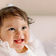 Valentina joined the competition — help win amazing prizes! baby, child, smiling, teeth, lace, white_clothing, earrings, curly_hair, portrait, closeup, happy, cute, infant, face, skin, young, indoors, soft_light, expression, joy