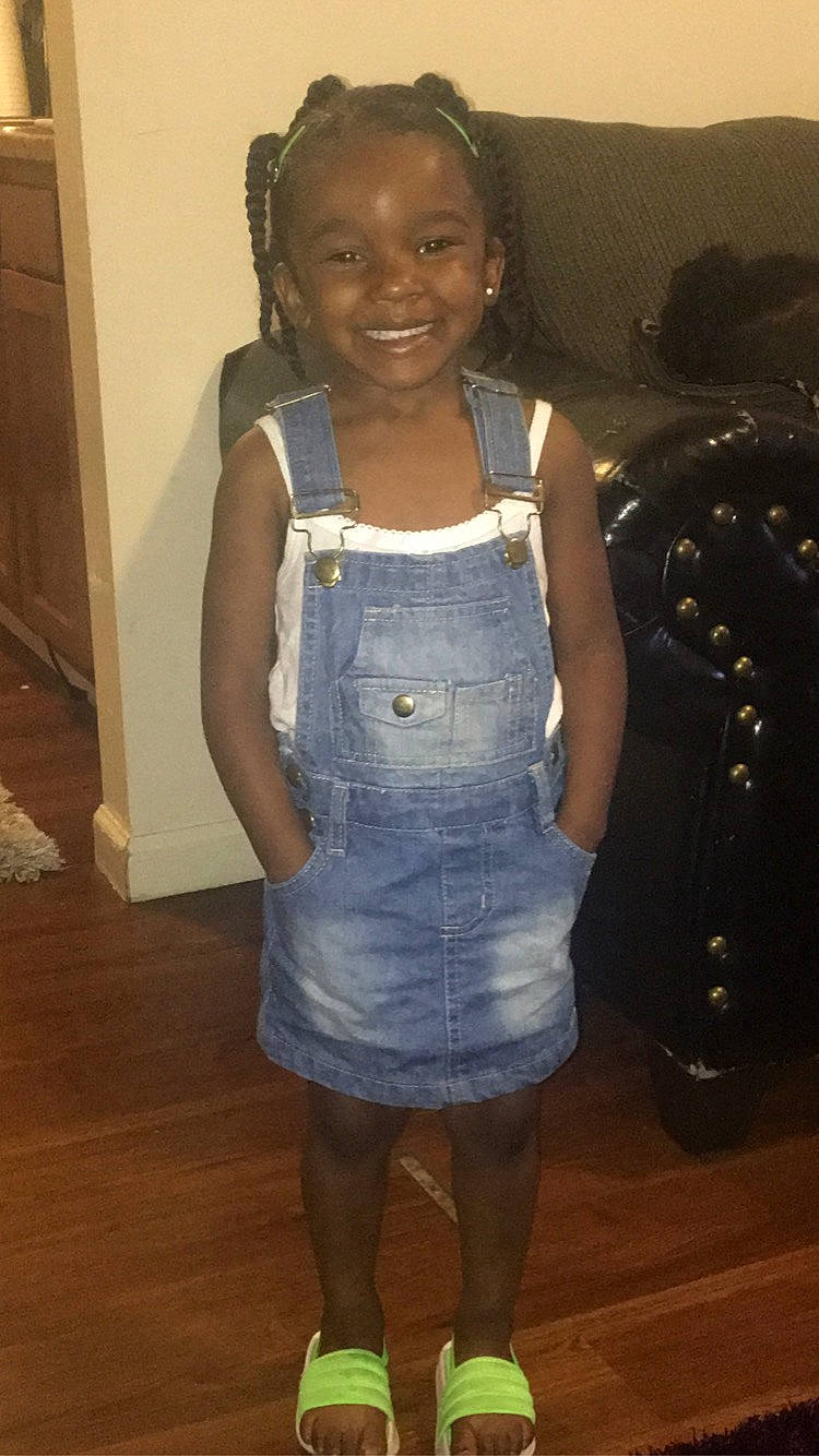 Samia is registered to the contest to win money with this photo: baby_toddler_clothing, black_hair, child, door, electric_blue, event, fashion_design, happy, human_leg, joint, joy, knee, long_hair, one_piece_garment, person, sleeve, smile, standing, thigh, trunk