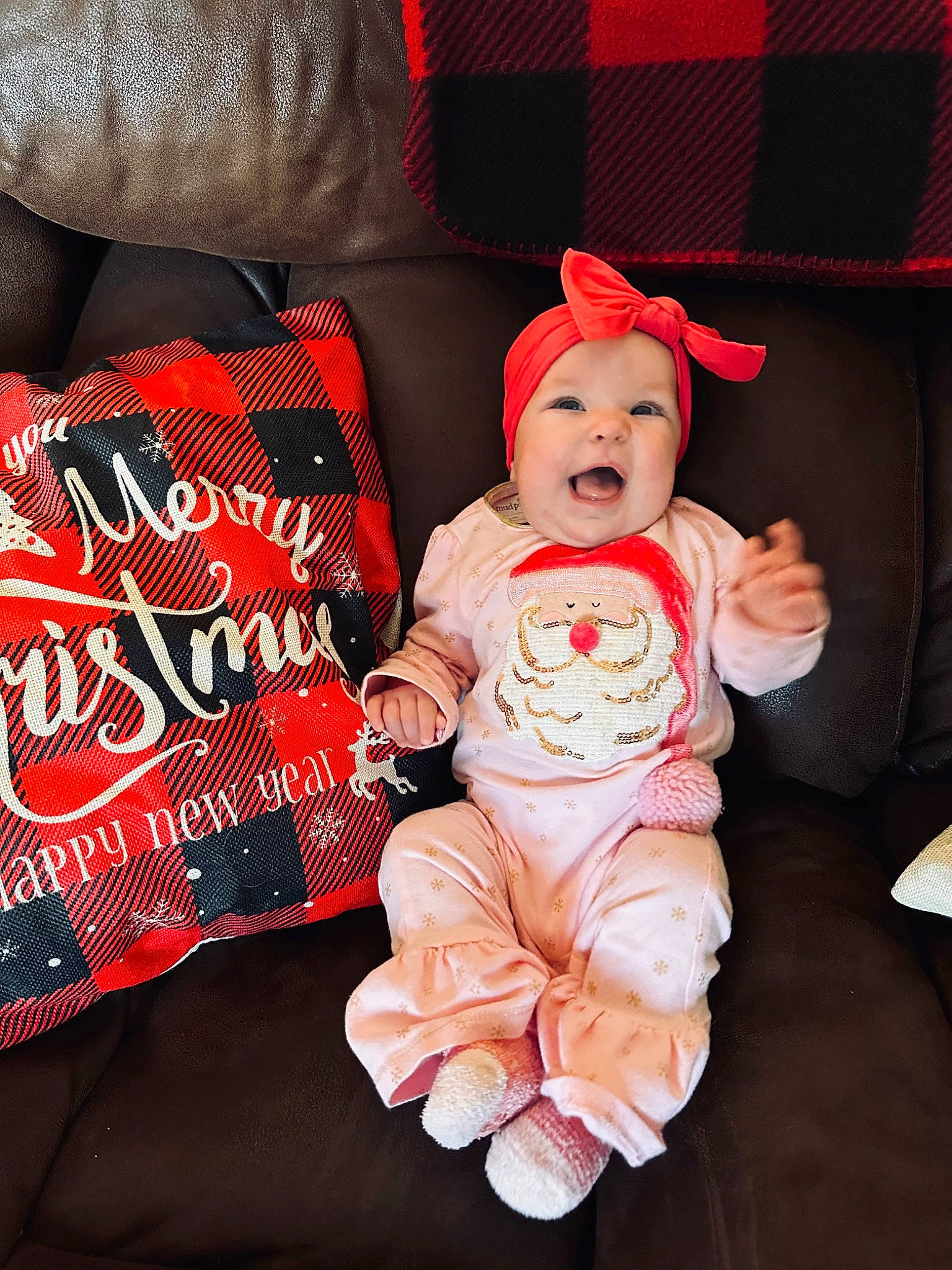 Oaklee is registered to the contest to win money with this photo: baby, baby_toddler_clothing, carmine, child, comfort, costume_hat, couch, eye, font, happy, hat, headwear, lap, person, pillow, red, sitting, sleeve, smile, t_shirt