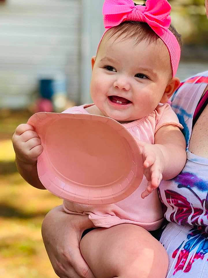 Echo is registered to the contest to win money with this photo: baby_playing_with_toys, baby_toddler_clothing, child, eye, face, facial_expression, finger, hairstyle, happy, headgear, human_body, joy, leisure, people, person, pink, red, shorts, skin, smile