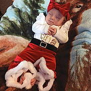 Chloe joined the competition — help win amazing prizes! baby, infant, sleeping, red_bow, festive_clothing, santa_outfit, blanket, deer_pattern, cozy, footwear, white_trim, hands_clasped, indoors, cute, holiday, toddler, soft_texture, headband, resting, portrait