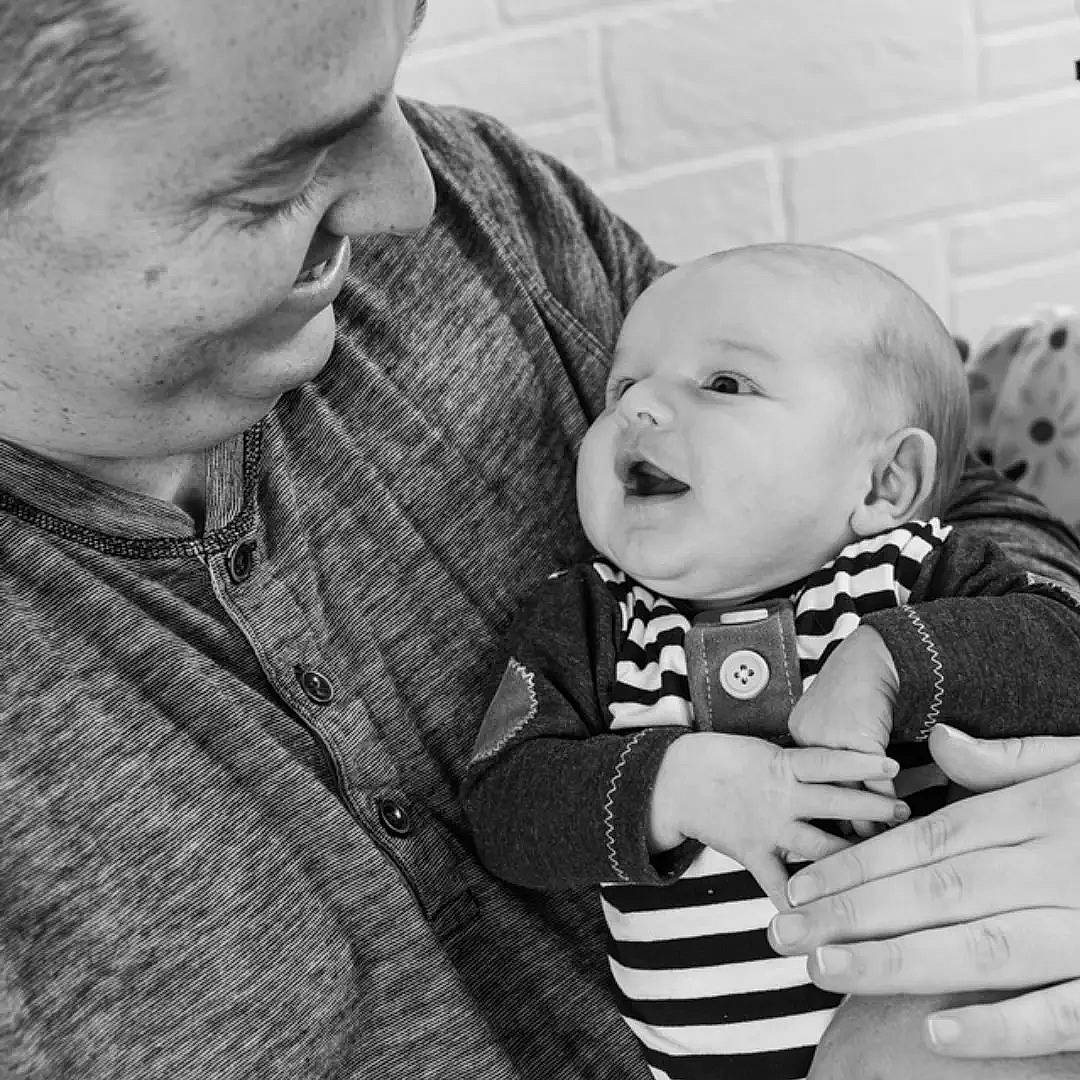 Koa is registered to the contest to win money with this photo: baby, baby_toddler_clothing, black_and_white, cheek, child, collar, comfort, facial_expression, gesture, happy, interaction, iris, monochrome, monochrome_photography, person, skin, sleeve, smile, standing, style