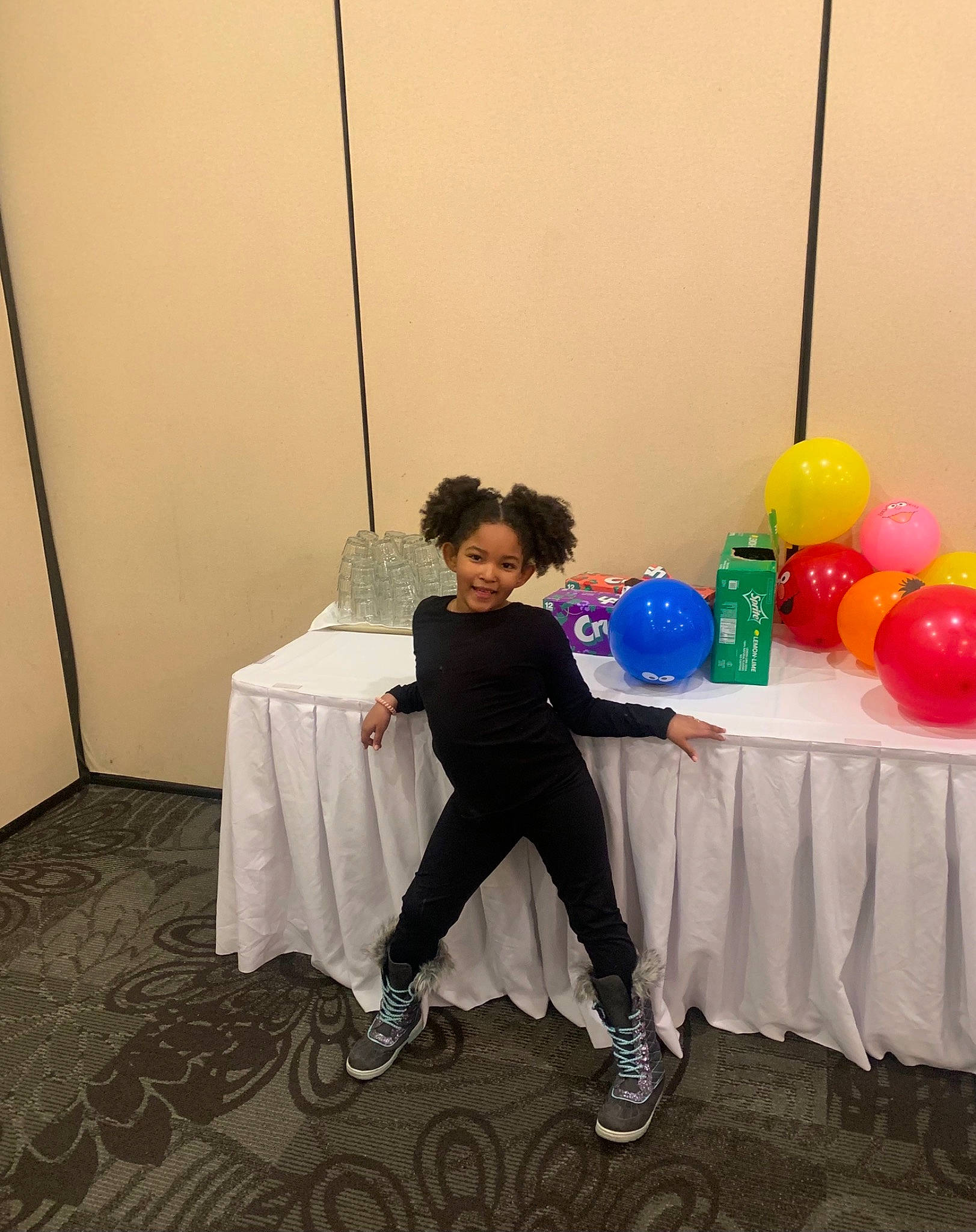 Aryana is registered to the contest to win money with this photo: balloon, child, clothing, costume, electric_blue, event, flooring, formal_wear, fun, furniture, joy, leisure, linens, party_supply, person, recreation, room, sandal, sitting, smile