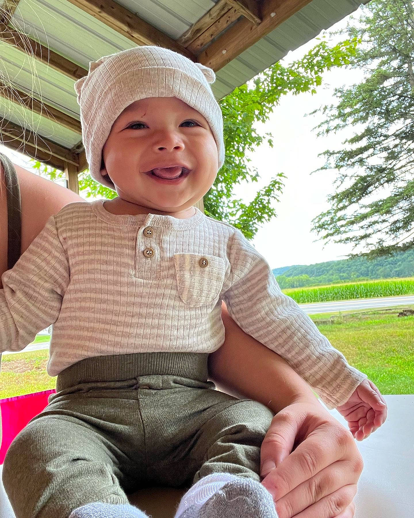 Josiah is registered to the contest to win money with this photo: baby_toddler_clothing, cap, cool, face, finger, grass, happy, hat, headgear, headwear, joy, leg, leisure, person, plant, skin, sleeve, smile, standing, textile