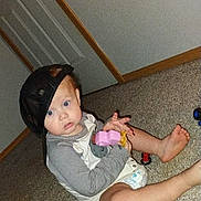 Creed joined the competition — help win amazing prizes! baby, child, indoor, carpet, toy, cap, hat, diaper, floor, door, walls, person, sitting, curious, blue_eyes, clothing, hand, foot, play, casual