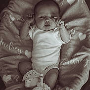 Audrey joined the competition — help win amazing prizes! baby, infant, blanket, onesie, crocheted_booties, heart_pattern, lying_down, curious_expression, soft_texture, cozy, monochrome, portrait, cute, newborn, hands, feet, fabric, sleepwear, resting, indoor