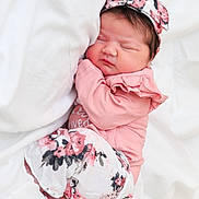 Everleigh joined the competition — help win amazing prizes! baby, newborn, sleeping, pink_clothing, headband, floral_pattern, infant, cute, soft_bedding, resting, peaceful, child, portrait, indoors, cozy, small_hands, closed_eyes, skin, hair, lying_down