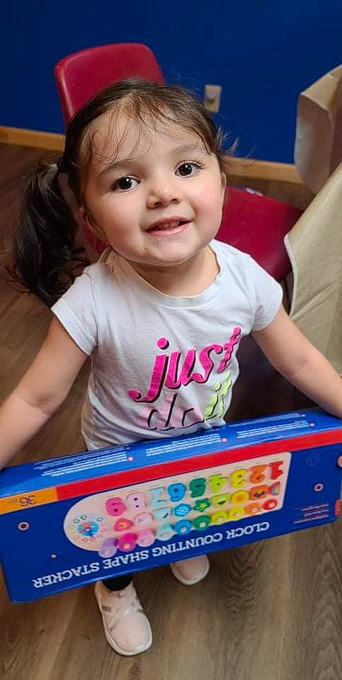 Nayely joined the competition — help win amazing prizes! baby, baby_playing_with_toys, blue, cheek, child, facial_expression, fun, happy, head, iris, joy, people, person, photograph, pink, product, red, skin, smile, standing