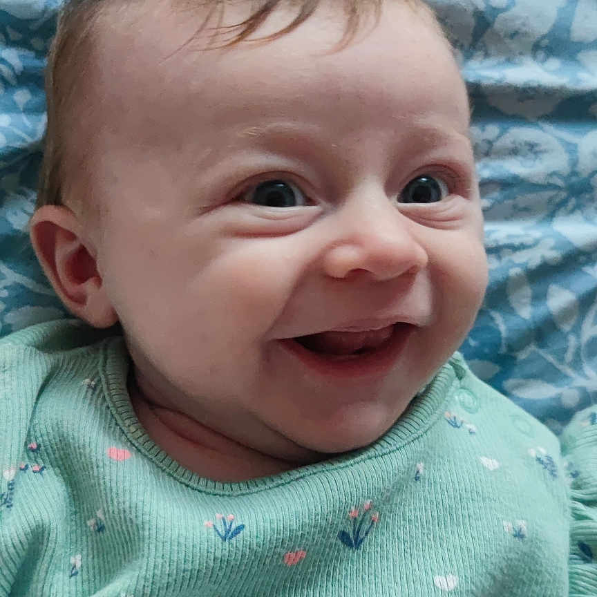 Ruby is registered to the contest to win money with this photo: applique, baby, babylaughing, bodypart, clothing, face, finger, hand, happy, head, knitwear, laughing, mouth, newborn, pattern, person, photography, portrait, smile, sweater