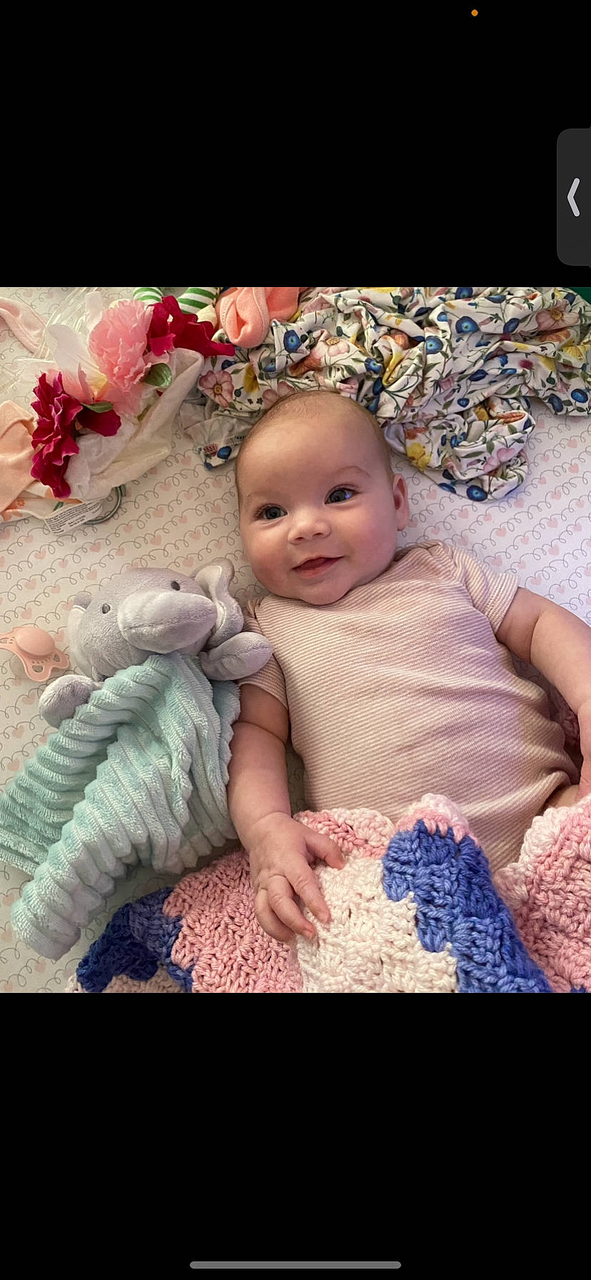 Kaileia is registered to the contest to win money with this photo: baby, baby_toddler_clothing, cheek, child, comfort, happy, iris, joy, linens, magenta, pattern, person, petal, pink, product, purple, sitting, skin, smile, textile