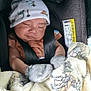 baby, car_seat, sleeping, hat, mittens, blanket, infant, child, cozy, cute, safety_belt, soft, patterned_blanket, peaceful, indoors, closeup, portrait, resting, comfort, evenflo