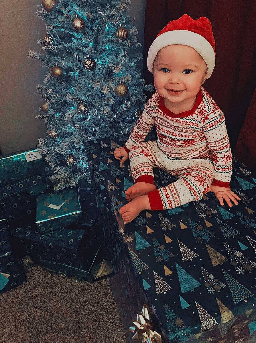 Tyce joined the competition — help win amazing prizes! baby, baby_toddler_clothing, bonnet, child, christmas, christmas_decoration, christmas_eve, christmas_lights, christmas_ornament, christmas_tree, conifer, costume_accessory, costume_hat, fictional_character, headwear, holiday, joy, ornament, pattern, person